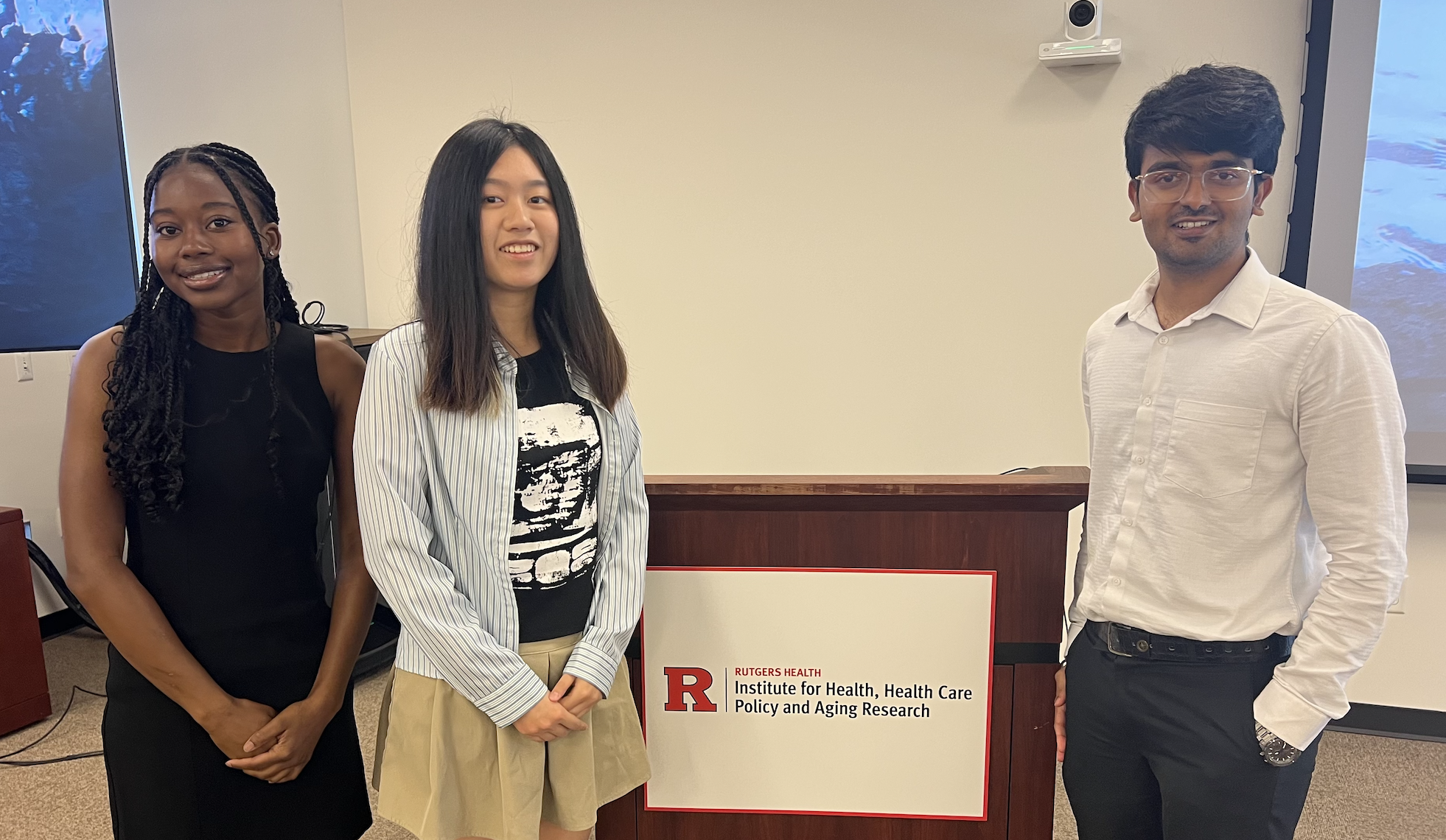 three student interns posing at the podium